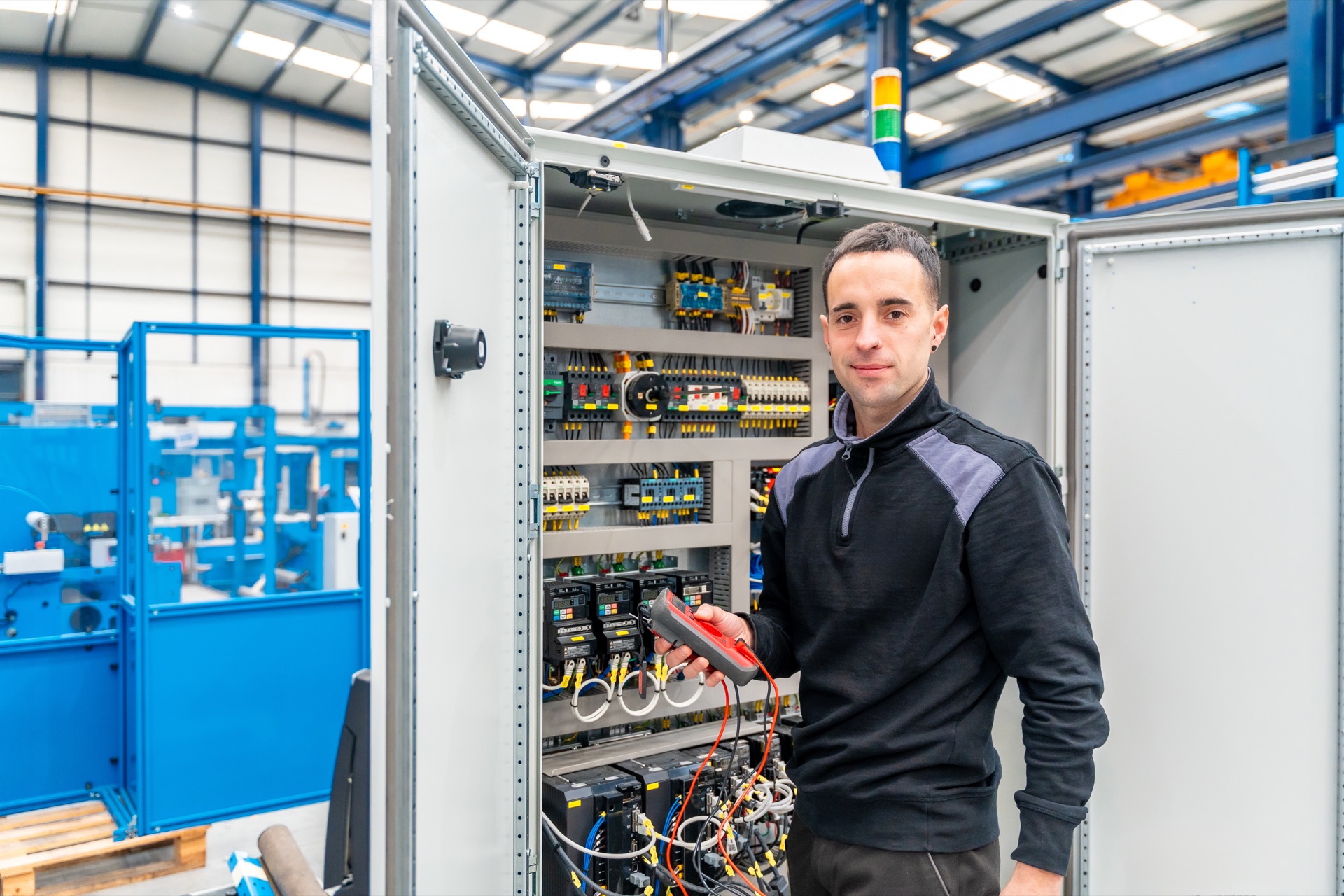Techniker bei Arbeiten im Schaltschrank einer Werkzeugmaschine